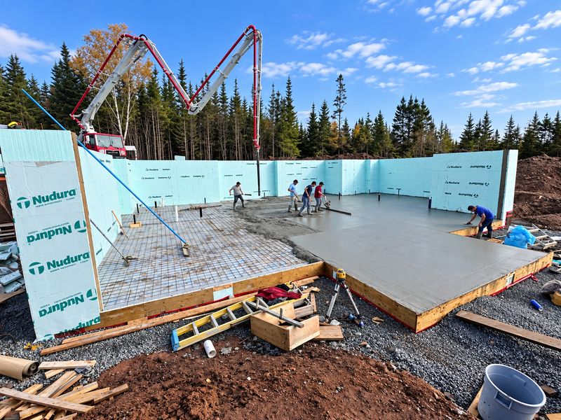Crew pouring a concrete slab inside ICF foundation walls, with a pump truck, Whiteside