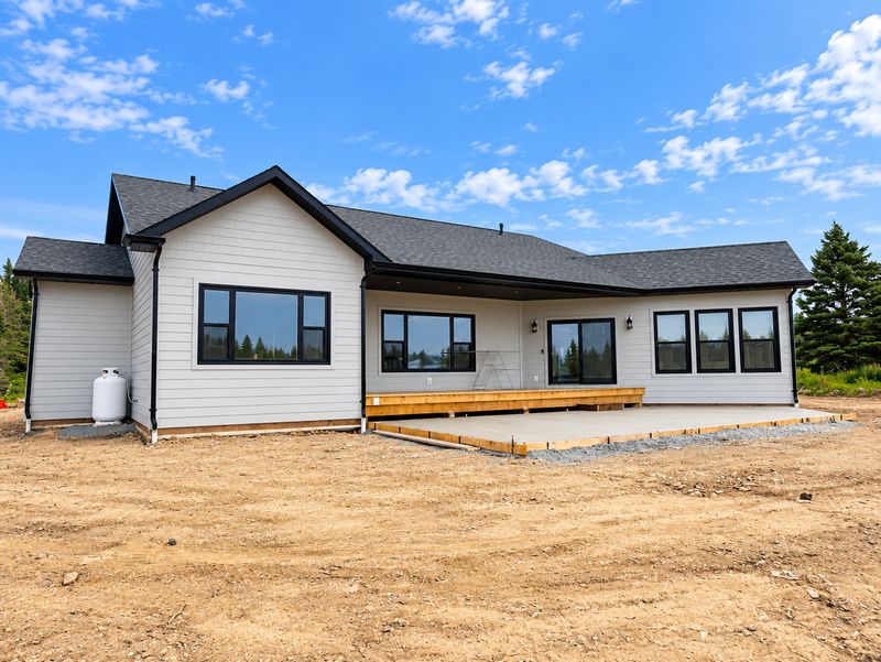 Back of a finished home with a deck and a concrete patio, Whiteside