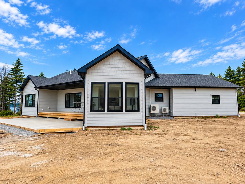 Back of a finished home with a row of three windows and two heat pumps, Whiteside